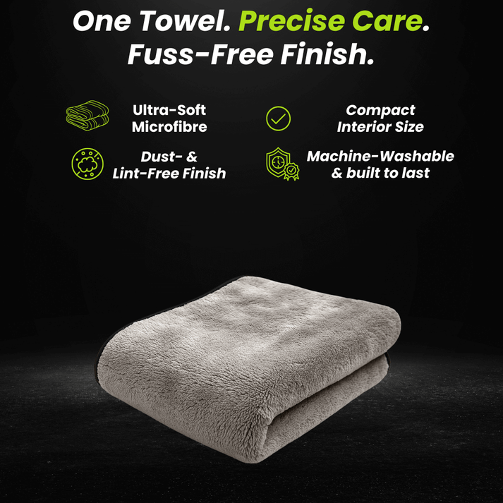 Folded gray microfiber car drying towel on a dark background.