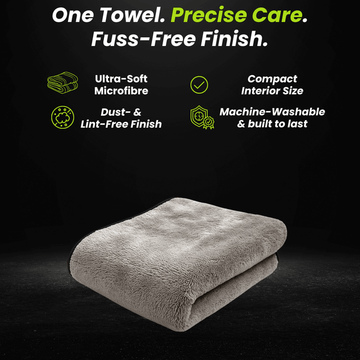 Folded gray microfiber car drying towel on a dark background.
