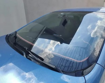 Rain droplets beading on a blue car windshield